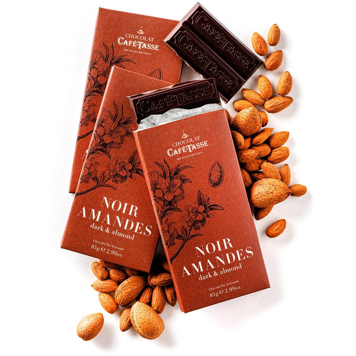 Café Tasse Noir Amandes dark chocolate bars with packaging and almonds on a white background