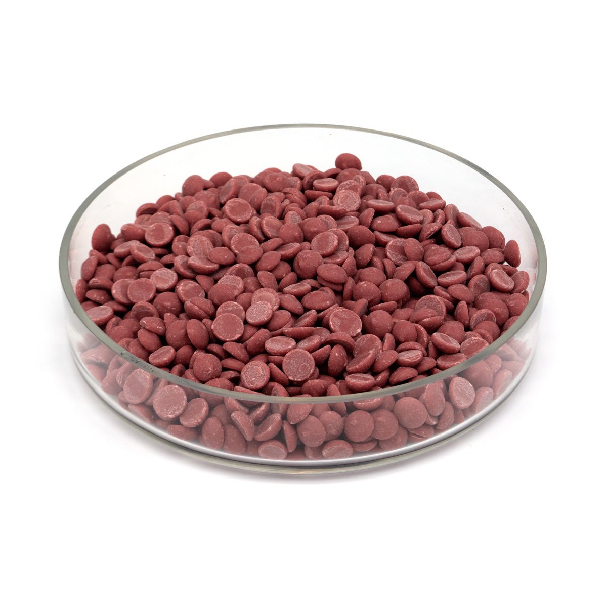 Red chocolate chips in a glass bowl on a white background
