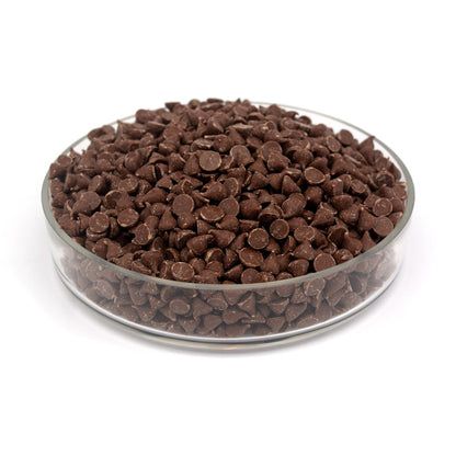 Glass bowl filled with chocolate chips on a white background