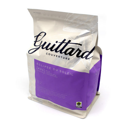 A stand-up pouch of Guittard Couverture chocolate, featuring a metallic silver and purple design with the brand name 'Guittard' in black script. The packaging is photographed on a clean white background.