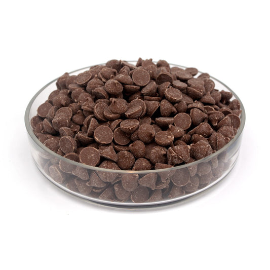 Glass bowl filled with large chocolate chips on a white background