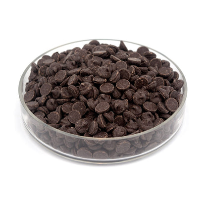 Glass bowl filled with large dark chocolate chips on a white background