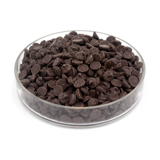 Glass bowl filled with large dark chocolate chips on a white background