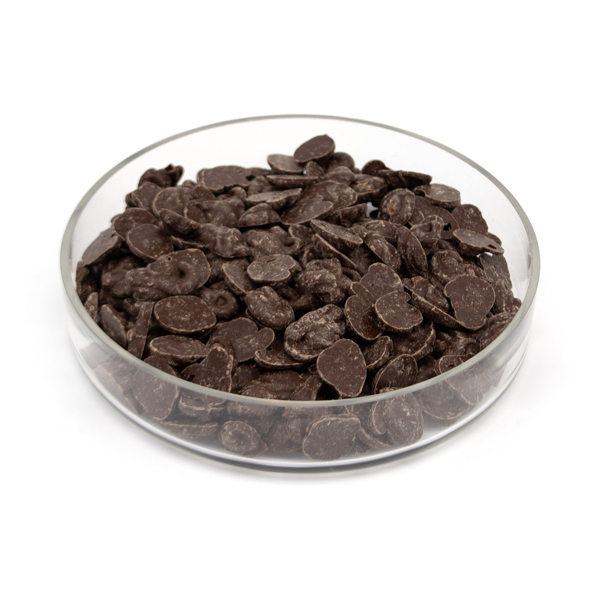 Dark chocolate melts piled in a clear glass bowl on a white background.