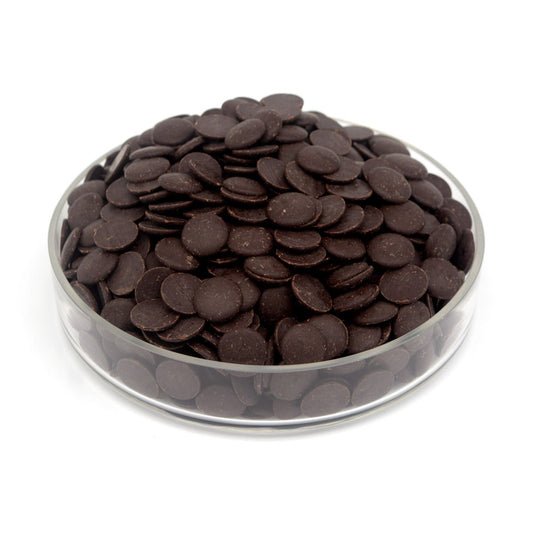 Glass bowl filled with dark chocolate wafers on a white background