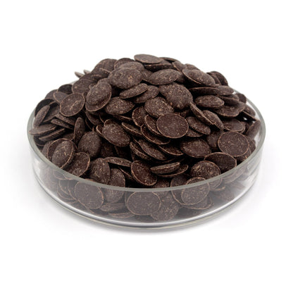 Glass container filled with dark chocolate wafers on a white background