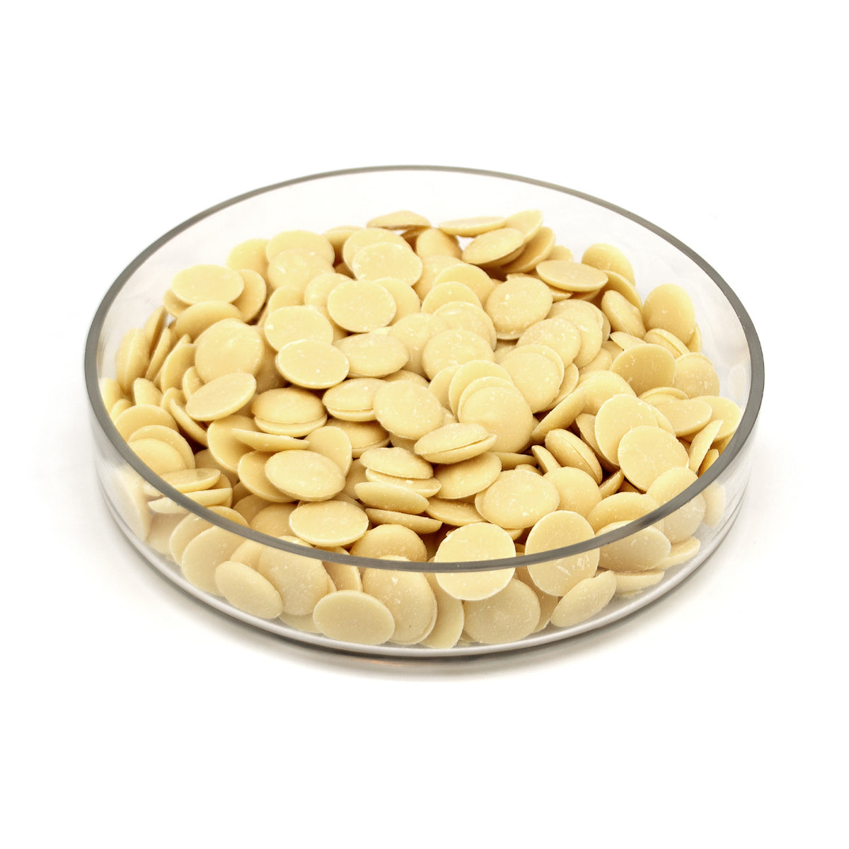 A clear glass bowl filled with round pale cream-colored chocolate discs, photographed on a clean white background.