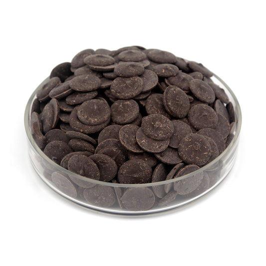 Glass bowl filled with dark chocolate wafers on a white background