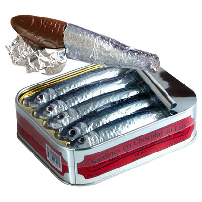 Tin of milk chocolate sardines with one partially unwrapped on a white background