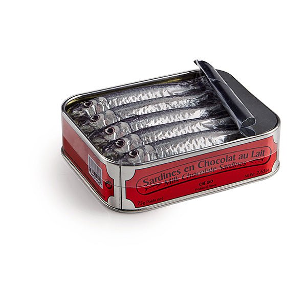 An open rectangular metal tin of milk chocolate sardines on a clean white background. The sardines are visible inside, and the red-and-silver label reads 'Sardines en Chocolat au Lait' with 'MILK CHOCOLATE SARDINES' below.