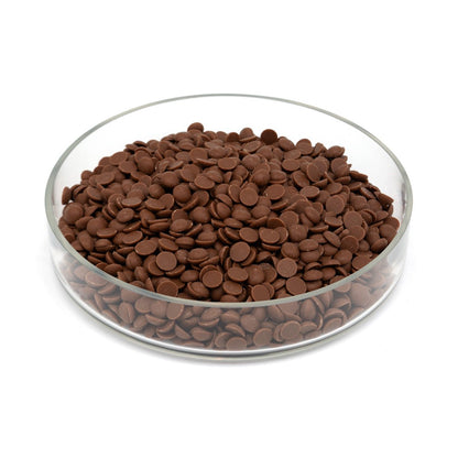 Glass bowl half filled with chocolate chips on a white background