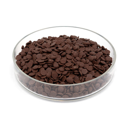 Glass bowl filled with chocolate discs on a white background