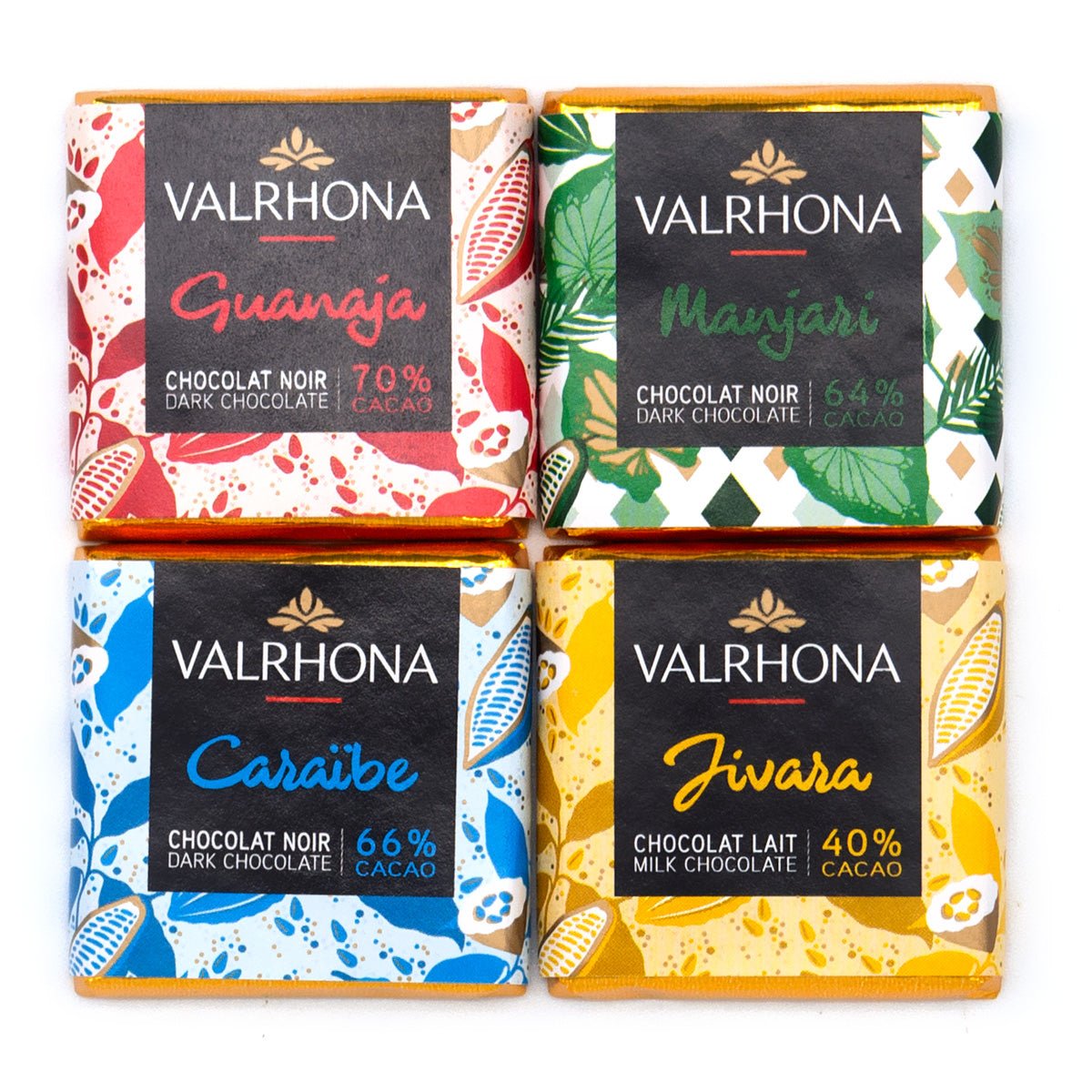 Four Valrhona dark chocolate squares arranged in a 2x2 grid on a white background. The top row features Guanaja (70% dark chocolate, black cocoa) in red and white patterns, and Manjari (64% dark chocolate) in green and white patterns. The bottom row features Caraibe (66% dark chocolate) in blue and white patterns, and Jivara (40% milk chocolate) in yellow and white patterns.