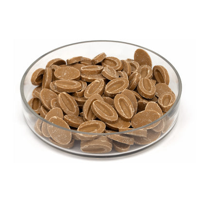 A clear glass bowl filled with oval brown chocolate discs, photographed on a clean white background.