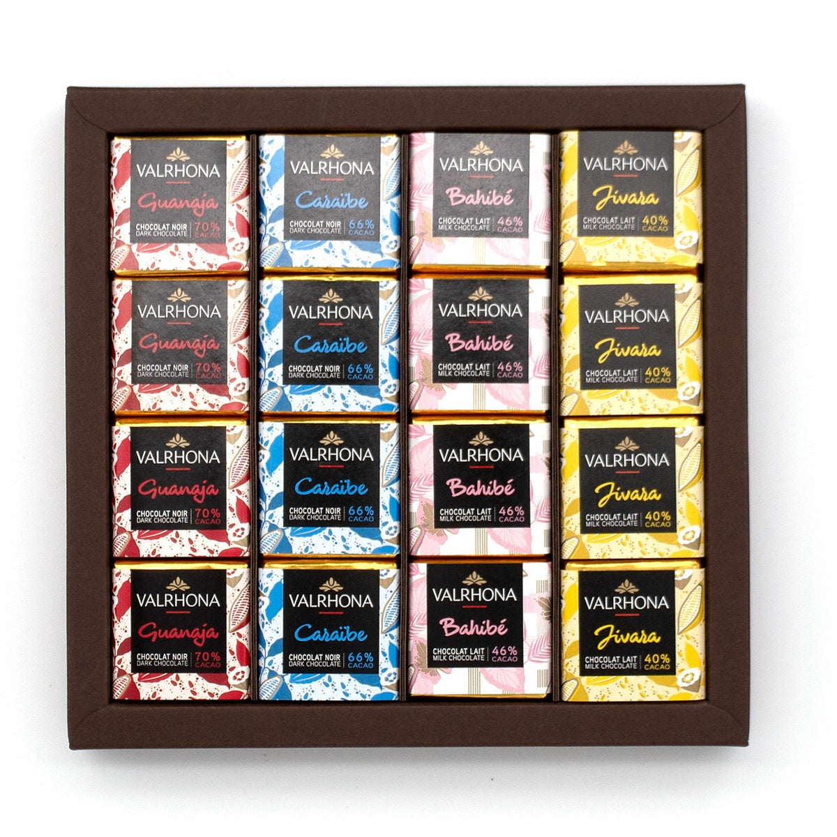 A Valrhona chocolate assortment box containing 16 individually wrapped chocolate bars arranged in a 4x4 grid inside a dark brown wooden tray. The wrappers feature different color schemes and flavor labels including Guanaja, Caraibe, Bahibe, and Jivara.