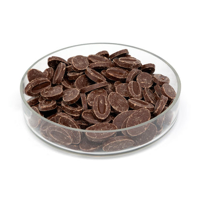 Glass bowl filled with chocolate feves on a white background