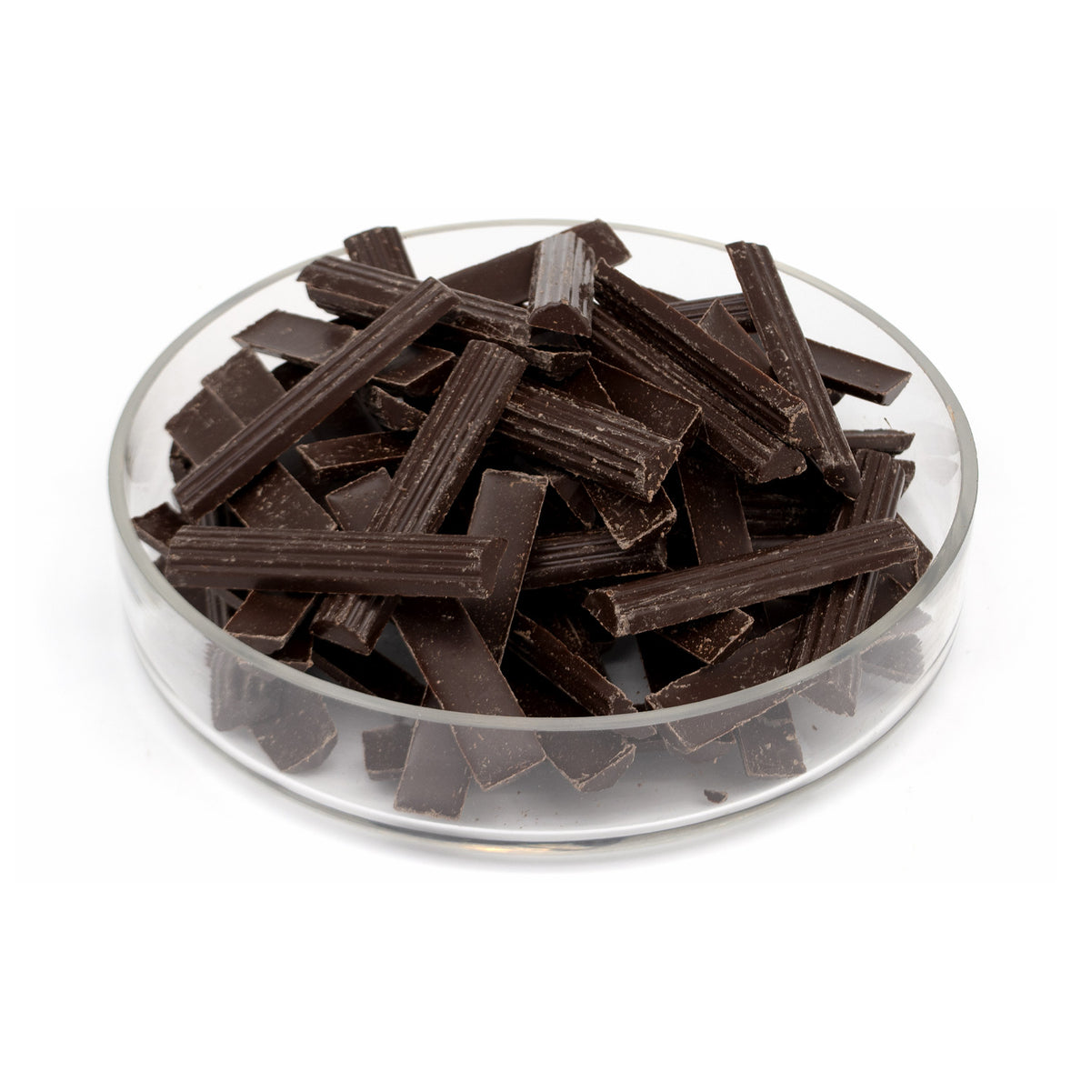 Valrhona chocolate batons piled in a clear glass dish on a white background