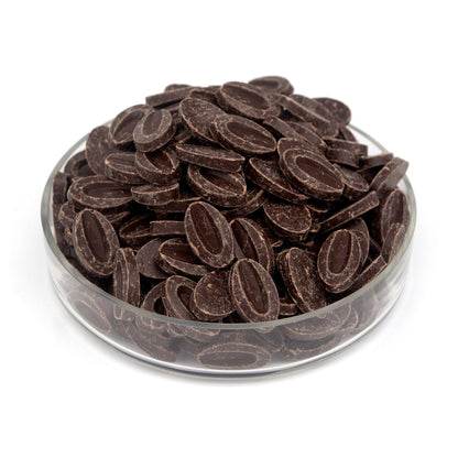 Glass bowl filled with chocolate feves on a white background